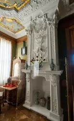 Камин в Спальне: по бокам лепные изображения ордена Андрея Первозванного, в центре — картуш, знамена и раковины